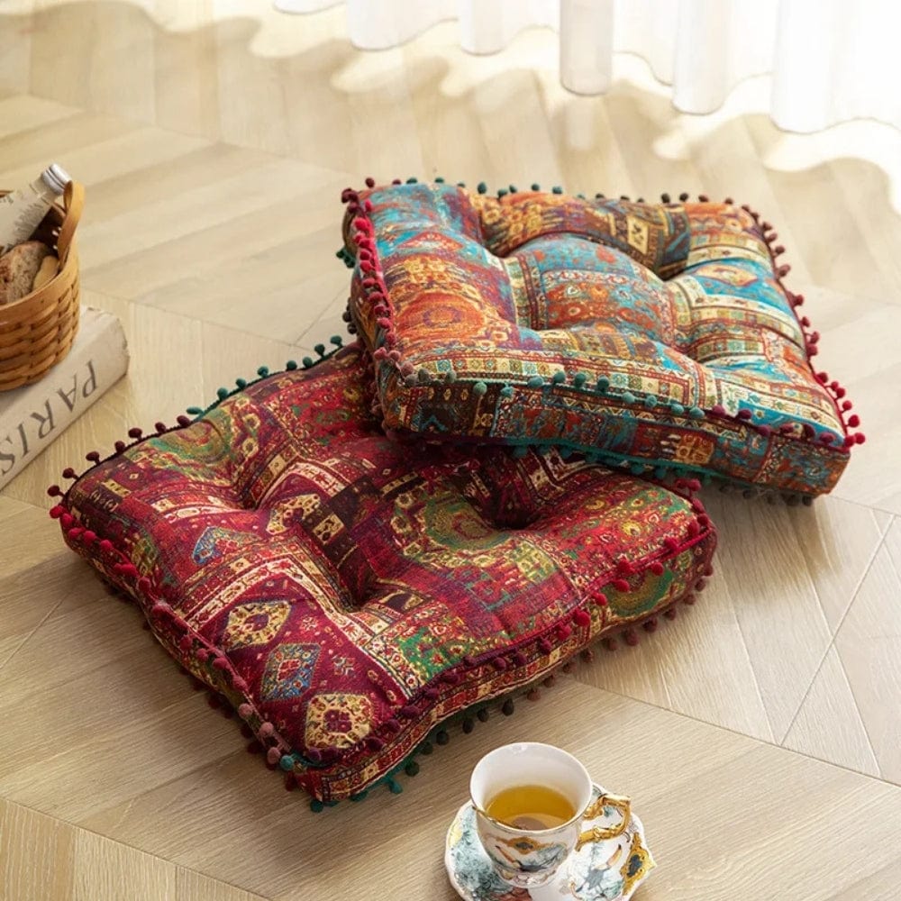 Coussins de sol colorés avec motifs géométriques, posés sur un parquet, créant une ambiance cosy pour la lecture