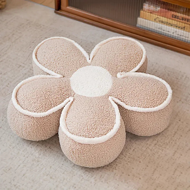 Coussin de sol en forme de fleur beige avec des contours blancs, posé sur un tapis dans un salon
