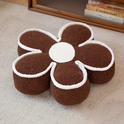 Coussin de sol en forme de fleur marron avec des contours blancs, posé sur un tapis clair dans un salon
