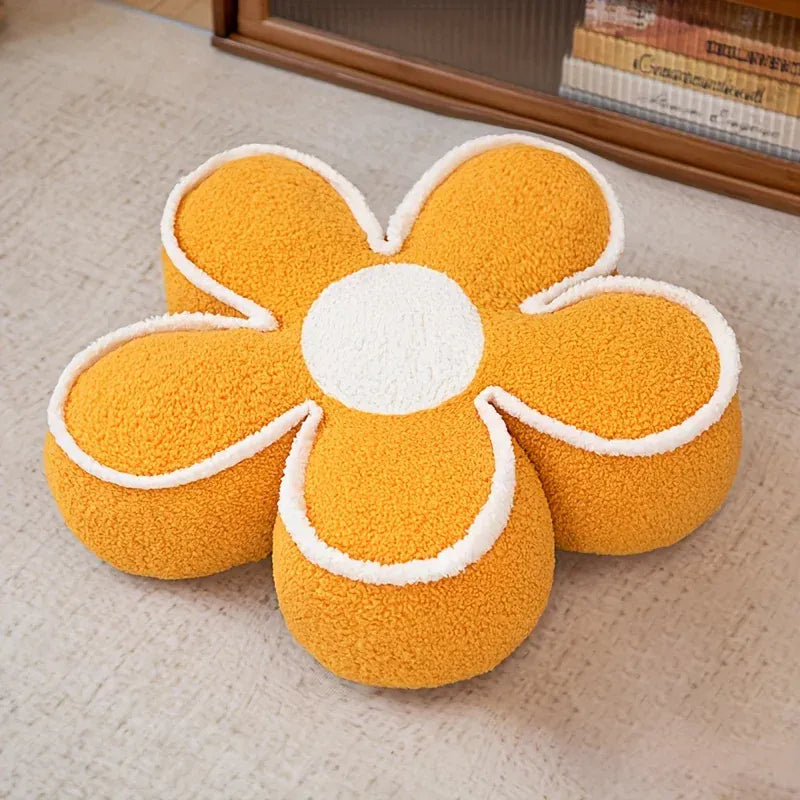 Coussin de sol en forme de fleur, couleur orange avec un centre blanc, posé sur un tapis doux