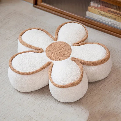 Coussin de sol en forme de fleur, avec des pétales blancs et un centre beige, posé sur un sol clair
