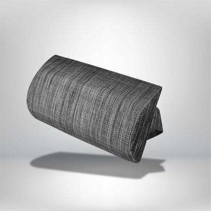 Coussin décoratif en tissu noir et gris, forme allongée, posé sur un fond neutre