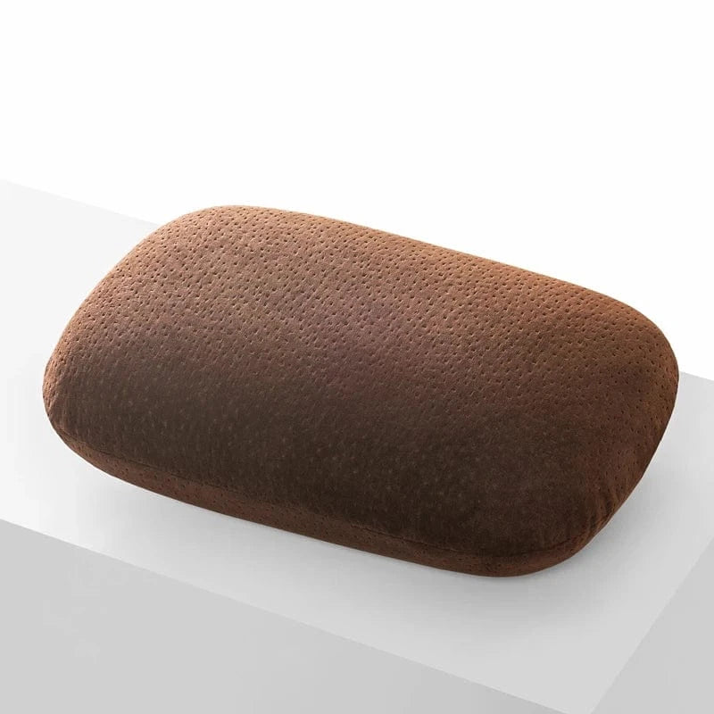 Coussin de voyage en mousse à mémoire de forme, couleur marron, posé sur une surface blanche