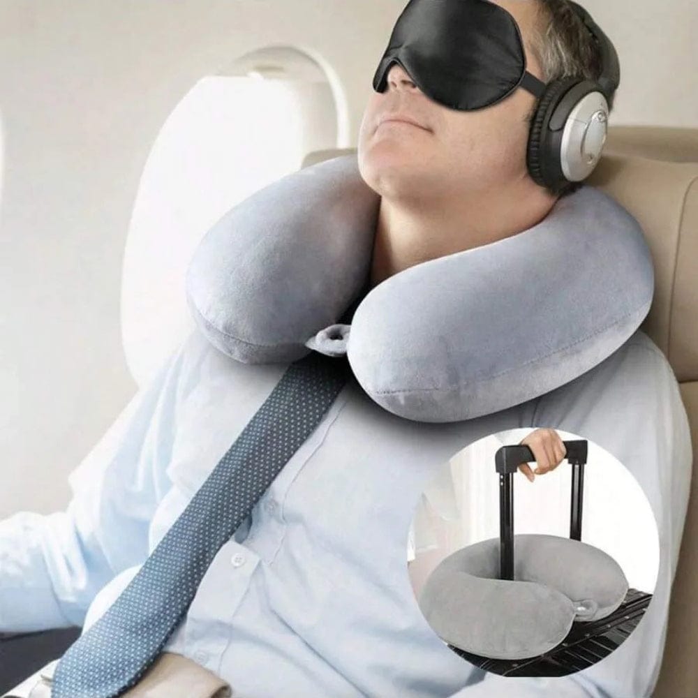 Coussin de voyage en velours gris, soutenant le cou d'un homme assis dans un avion, avec un masque de sommeil