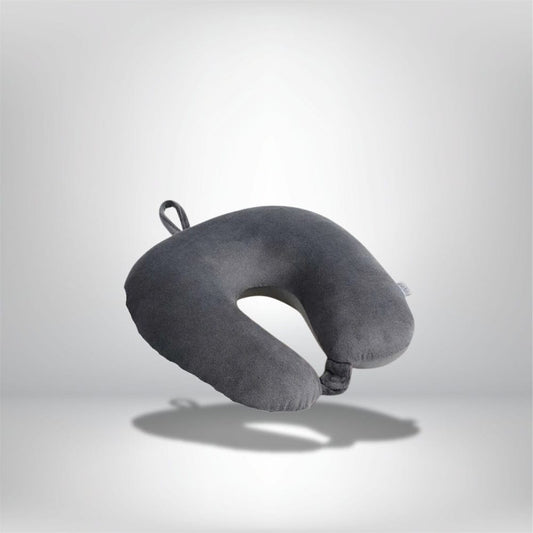 Coussin de voyage en velours gris en forme de U, posé sur un fond neutre, idéal pour un confort optimal