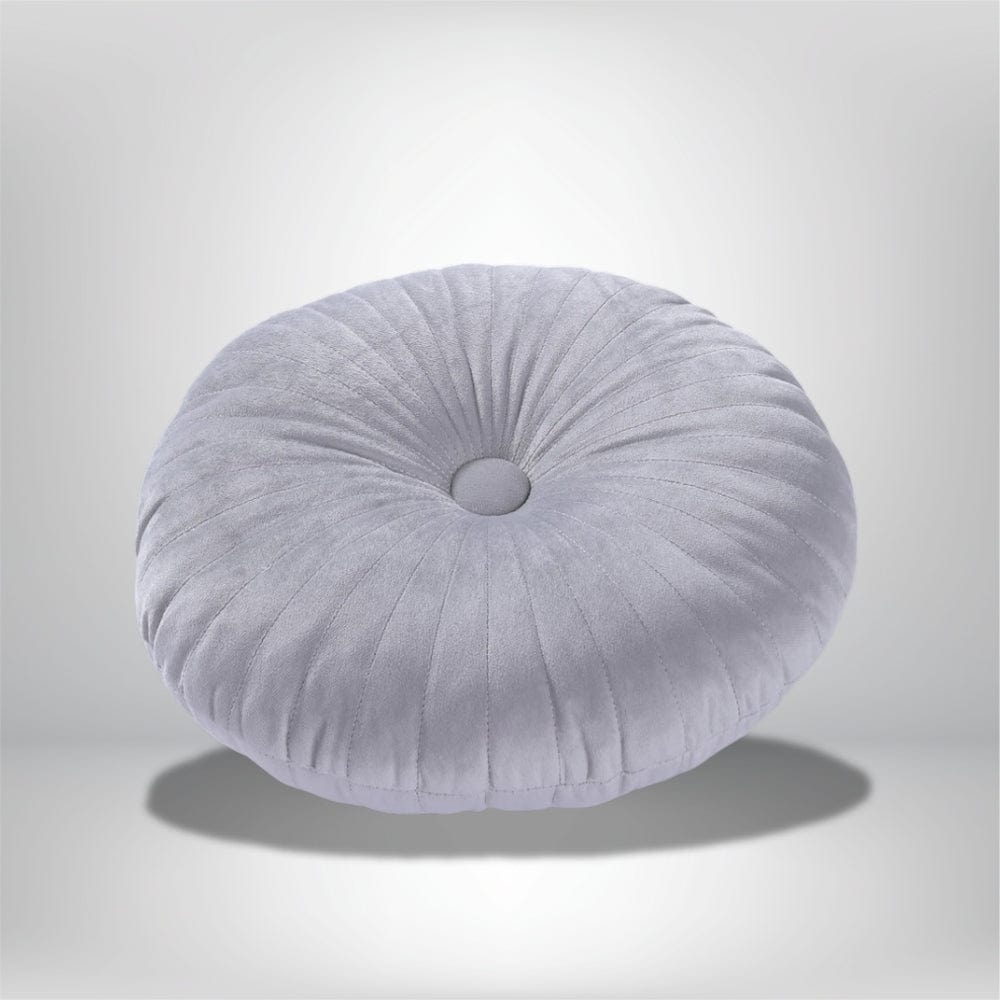 Coussin déco rond en velours gris clair avec des plis, posé sur un fond neutre