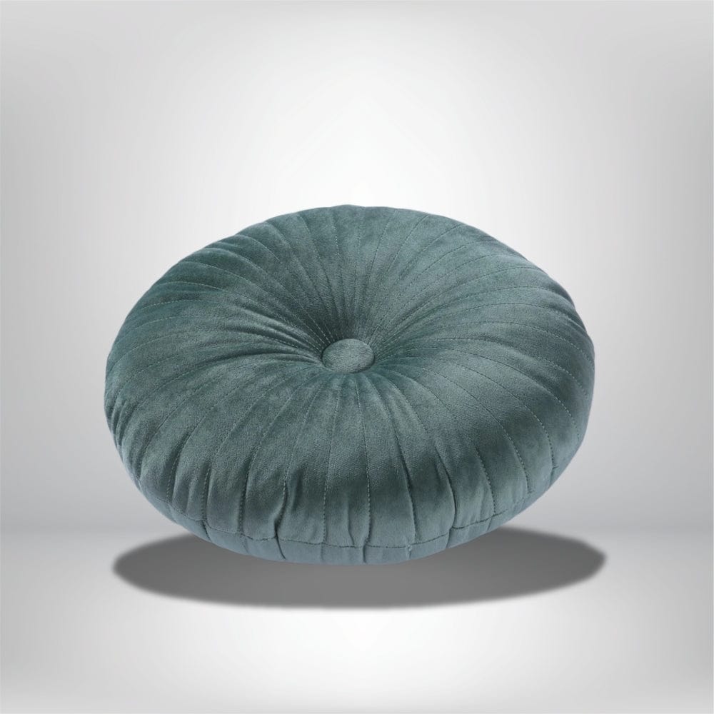 Coussin déco rond en velours vert avec des plis, posé sur un fond neutre, idéal pour un canapé