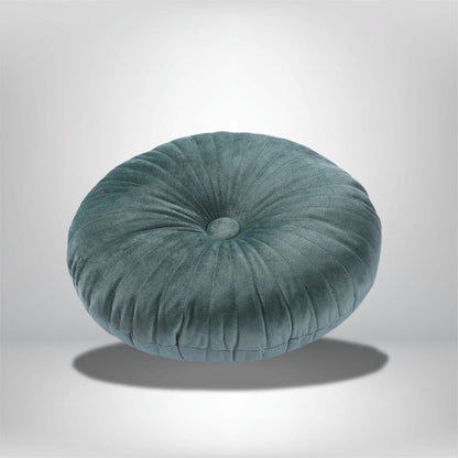 Coussin déco rond en velours vert avec des plis, posé sur un fond neutre, idéal pour un canapé