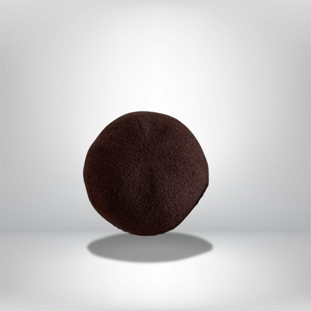 Coussin décoratif rond en tissu marron, posé sur une surface neutre, idéal pour un canapé moderne