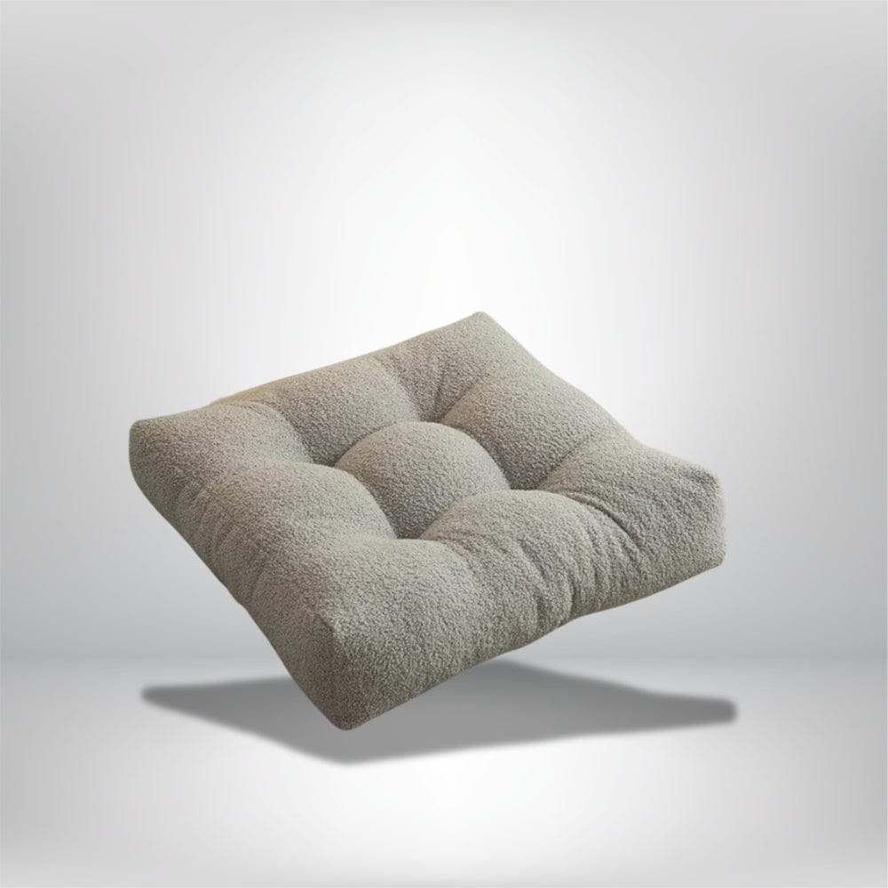 Coussin décoratif beige en matière douce, forme carrée, posé dans un salon moderne avec un éclairage doux