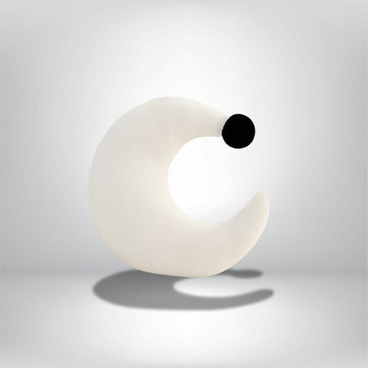 Coussin demi-lune blanc avec un point noir, idéal pour décorer un fauteuil moderne dans un salon