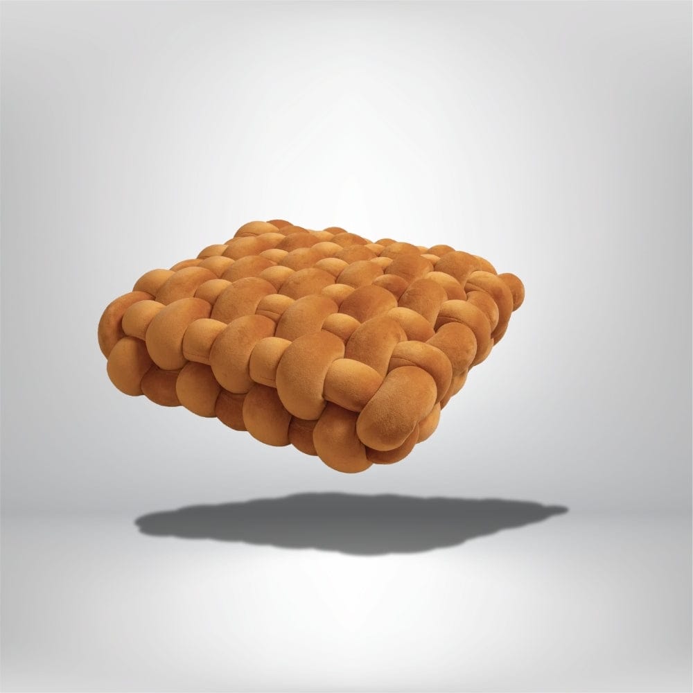 Coussin décoratif en velours orange, forme carrée, posé sur un fond neutre, idéal pour un canapé moderne