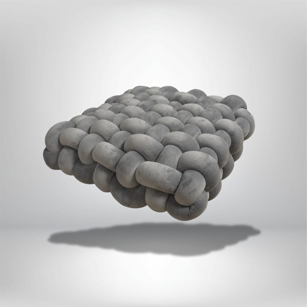 Coussin déco en velours gris, design moderne, posé sur un fond neutre, forme carrée et texturé