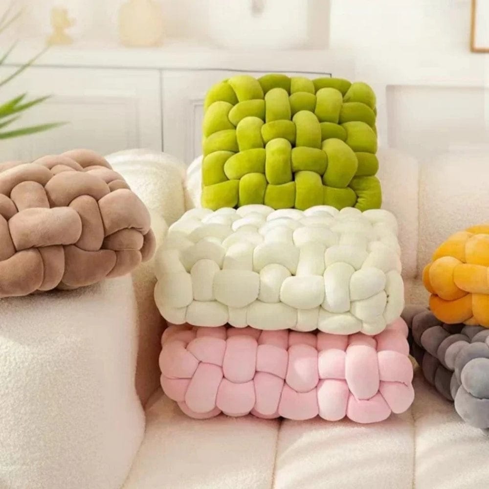 Coussins décoratifs aux couleurs pastel, en velours, disposés sur un canapé moderne dans un salon lumineux