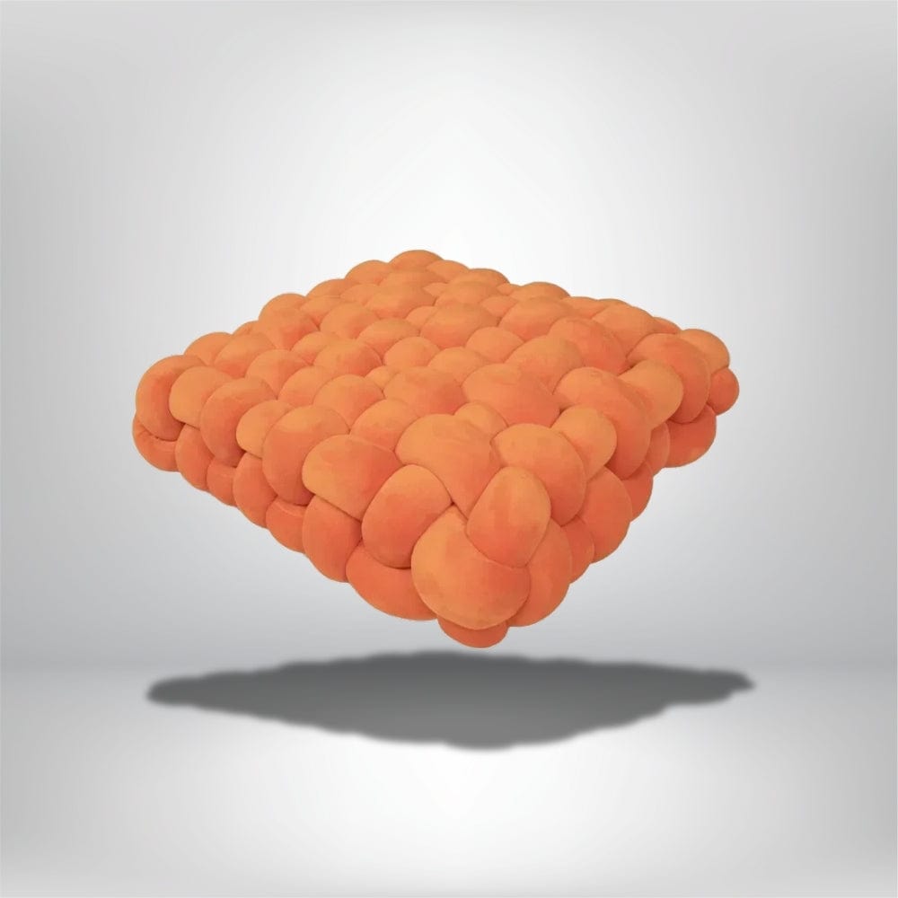 Coussin déco moderne en tissu doux, de forme carrée et couleur orange, sur fond neutre