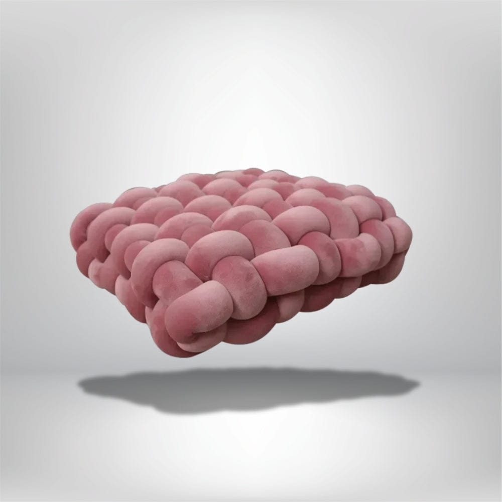 Coussin déco en velours rose, au design moderne, posé sur un fond neutre, évoquant confort et élégance