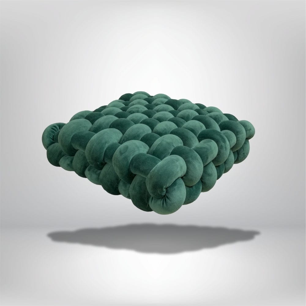 Coussin déco en velours vert, design moderne, posé sur un fond neutre, idéal pour un salon contemporain