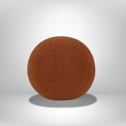 Coussin déco rond en velours marron, posé sur une surface neutre, idéal pour un canapé moderne