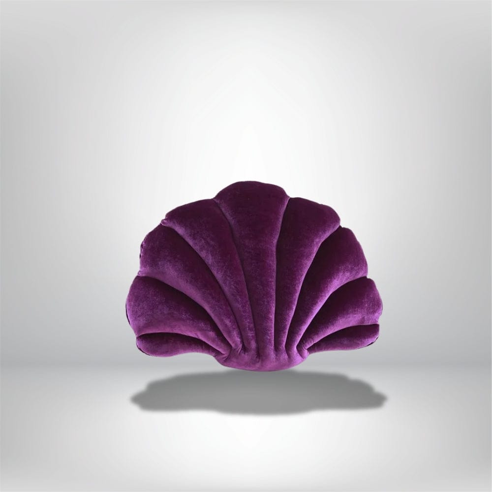 Coussin décoratif en velours violet en forme de coquillage, posé sur une surface neutre
