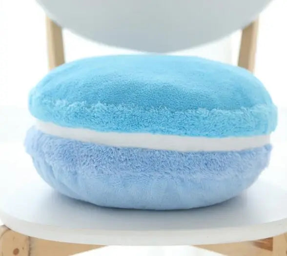 Coussin déco en forme de macaron, en tissu doux bleu et bleu clair, posé sur une chaise moderne