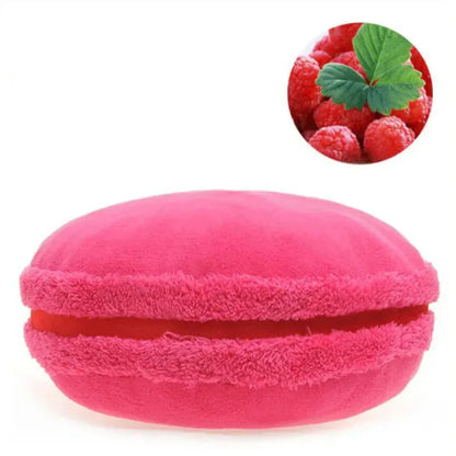 Coussin décoratif en forme de macaron, couleur rose vif, posé sur un canapé moelleux