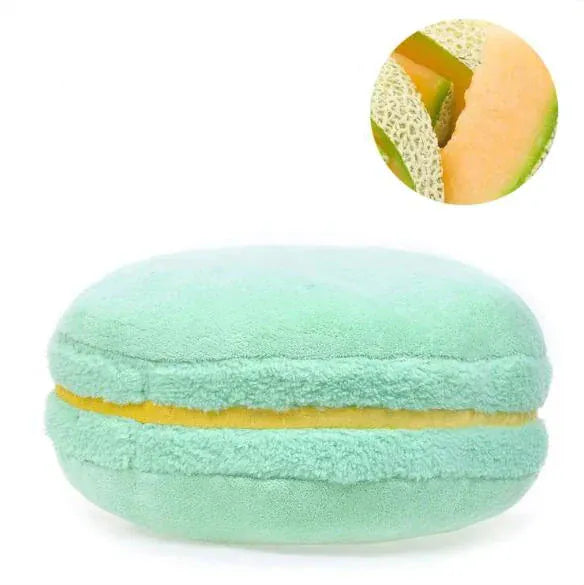 Coussin déco en forme de macaron, aux couleurs vertes et jaunes, posé sur un canapé moderne