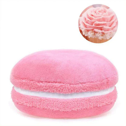 Coussin déco en forme de macaron, en velours rose, posé sur un canapé moderne