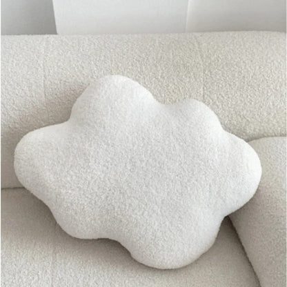 Coussin en forme de nuage, couleur blanche, posé sur un canapé texturé, ajoutant une touche déco douce et moderne