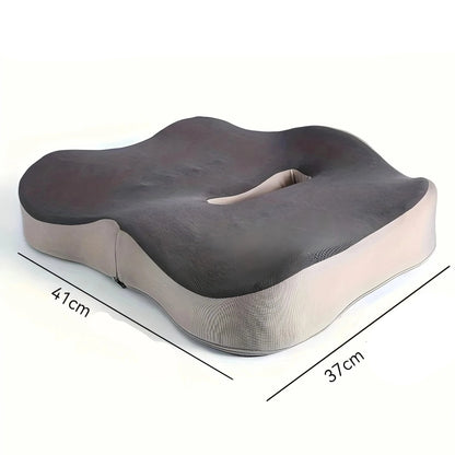 Coussin ergonomique de couleur gris et beige, avec une forme ondulée, posé sur une chaise