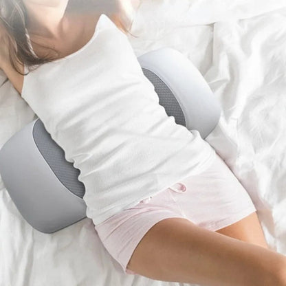 Coussin ergonomique gris sur un lit blanc, apportant confort et soutien pour le dos