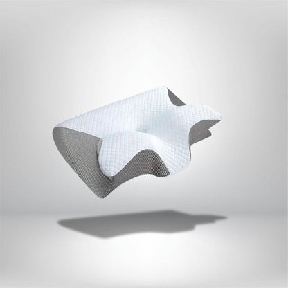 Coussin ergonomique blanc avec motif matelassé, posé sur un fond gris, idéal pour le confort du nuque