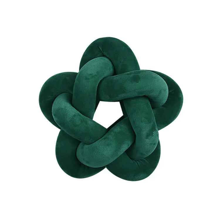 Coussin décoratif en velours vert en forme d'étoile, posé sur un canapé moderne et élégant