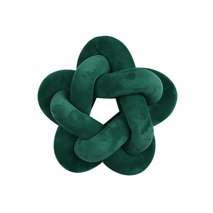 Coussin décoratif en velours vert en forme d'étoile, posé sur un canapé moderne et élégant