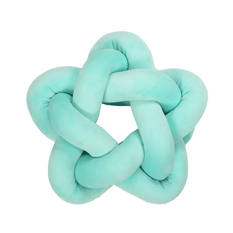Coussin décoratif en forme d'étoile, en velours turquoise, posé sur un canapé moderne