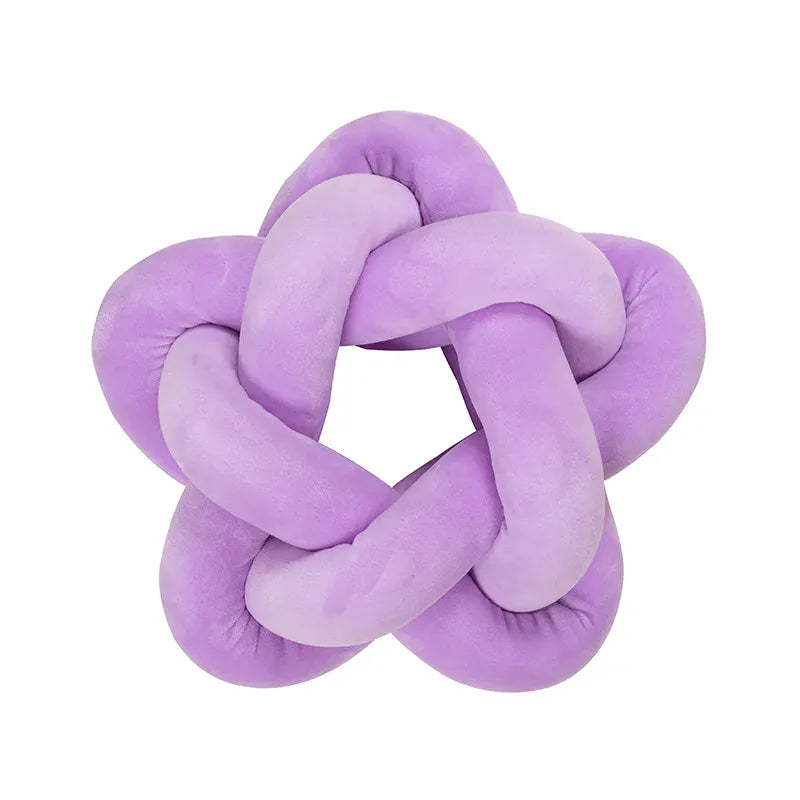 Coussin décoratif en forme d'étoile, en velours violet, posé sur un canapé moderne
