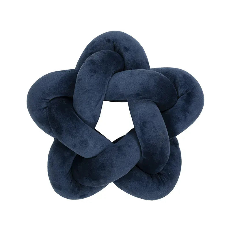Coussin décoratif en velours bleu marine en forme d'étoile, posé sur un canapé moderne
