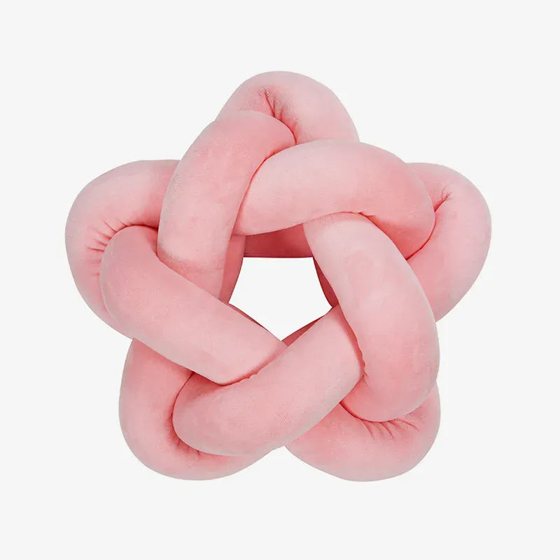 Coussin décoratif en forme d'étoile, en velours rose, posé sur un canapé moderne