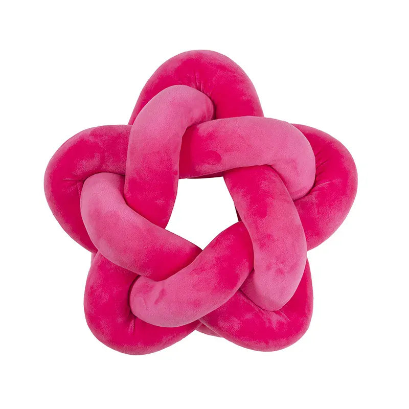 Coussin décoratif en forme d'étoile, en velours rose, posé sur un canapé moderne