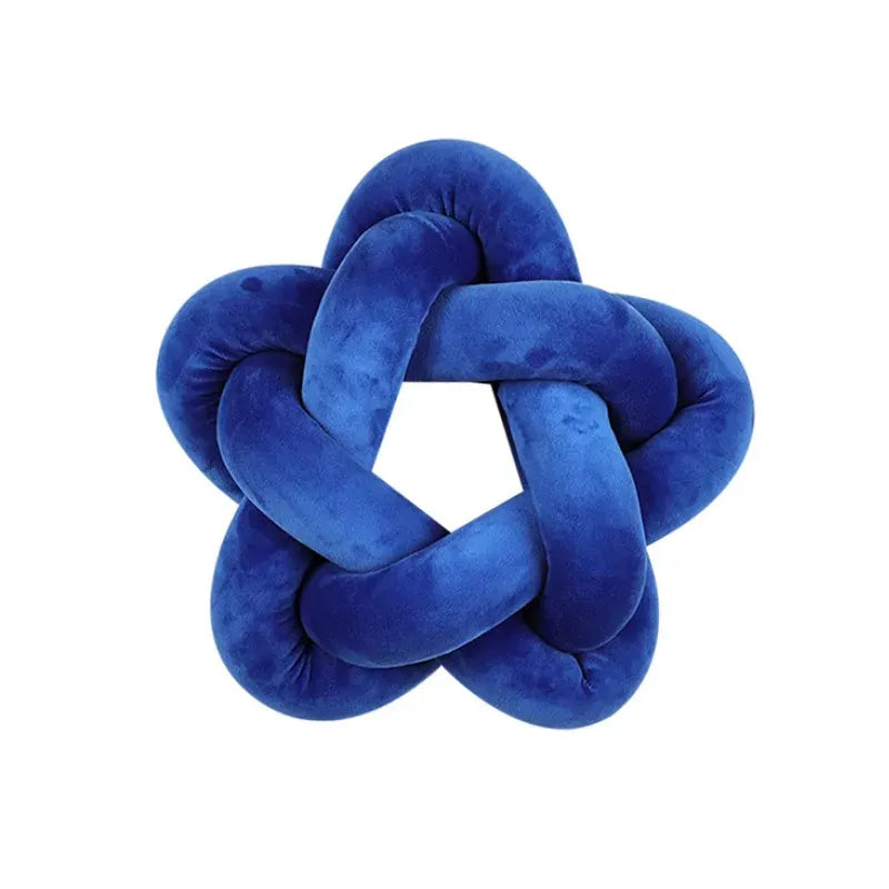 Coussin décoratif en velours bleu en forme d'étoile, posé sur un canapé moderne