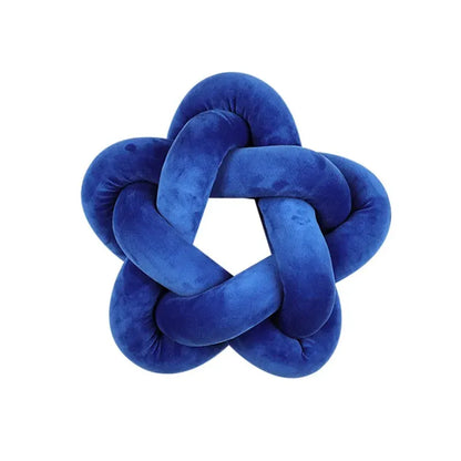 Coussin décoratif en velours bleu en forme d'étoile, posé sur un canapé moderne