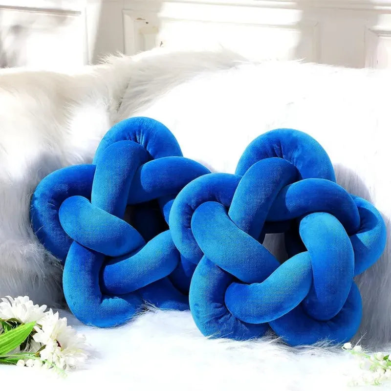 Coussins décoratifs en velours bleu en forme d'étoile avec nœud, posés sur un canapé moelleux