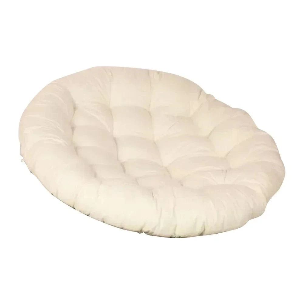 Coussin décoratif oval en tissu beige, moelleux, posé sur une surface extérieure, idéal pour un salon de jardin