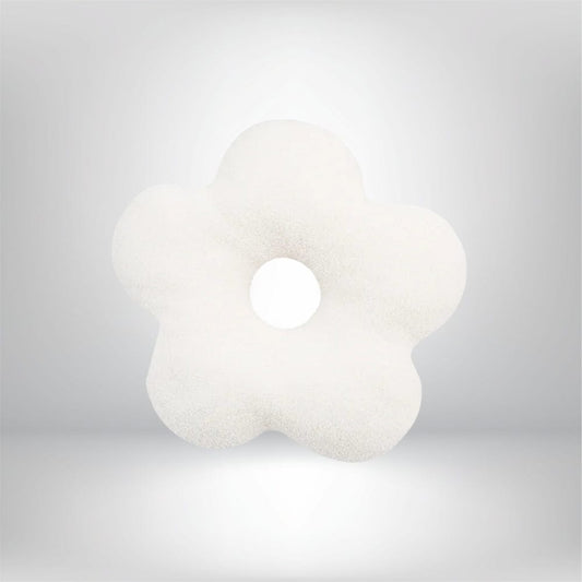 Coussin décoratif en forme de fleur blanche, avec un trou central, sur un fond neutre