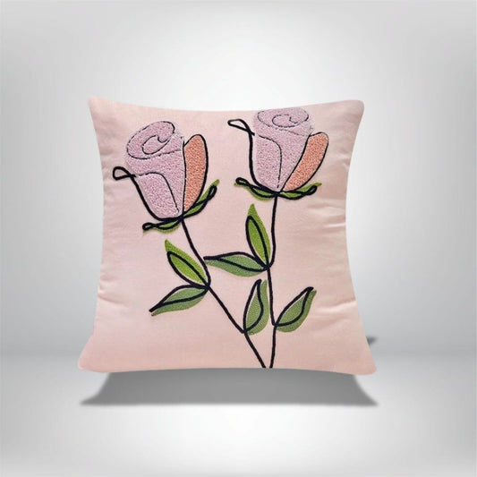 Coussin décoratif rose avec motifs de fleurs brodées, posé sur un fond neutre, idéal pour un canapé ou une chambre