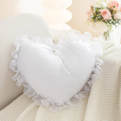 Coussin décoratif en forme de cœur blanc avec un volant en tissu transparent sur un canapé beige