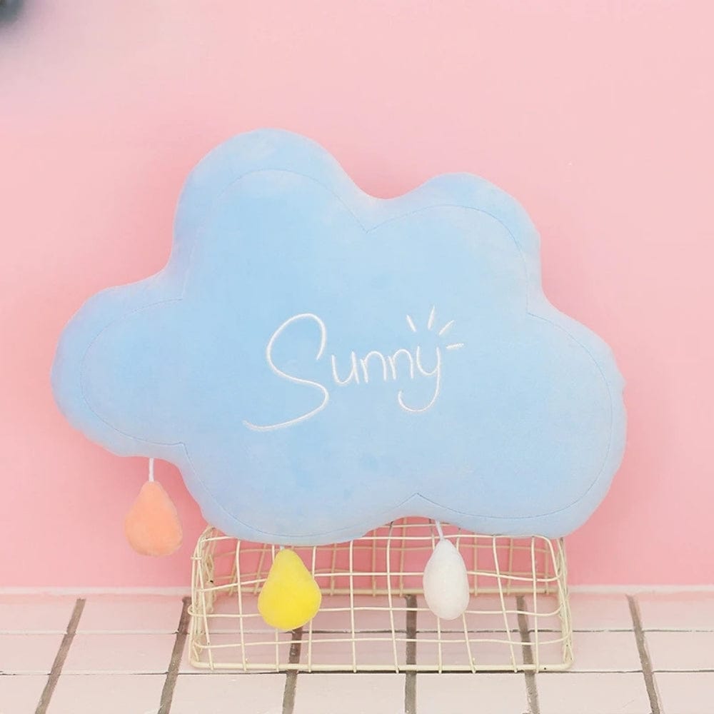 Coussin décoratif en forme de nuage bleu avec des gouttes colorées, posé sur un support en métal