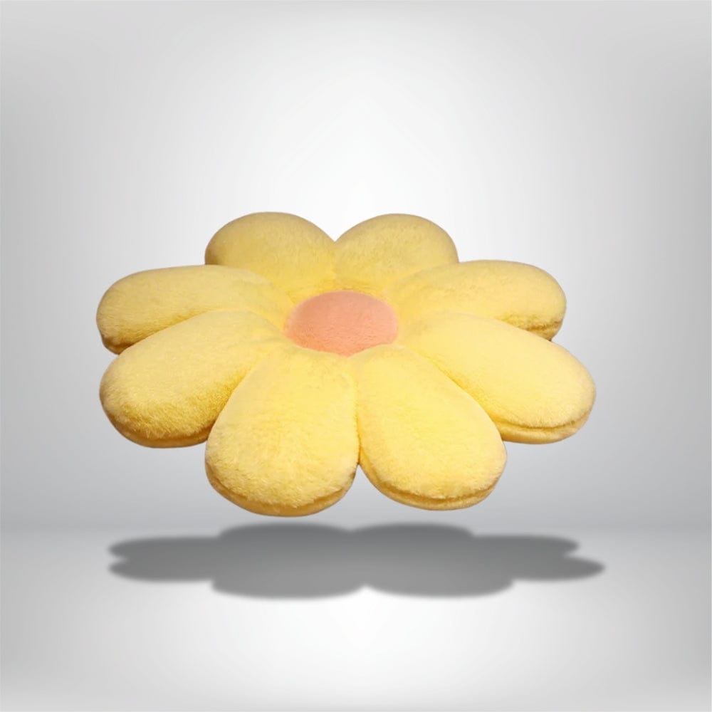 Coussin décoratif en forme de fleur, jaune avec un centre rose, posé sur un fond neutre