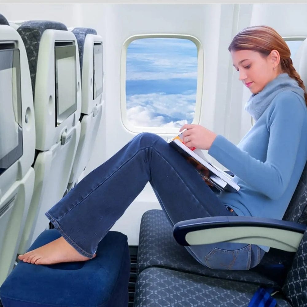 Coussin gonflable bleu posé sur un siège d'avion, offrant un confort pour reposer les pieds