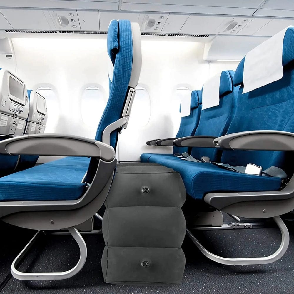 Coussin gonflable noir placé entre des sièges d'avion bleus, offrant un confort supplémentaire lors des vols