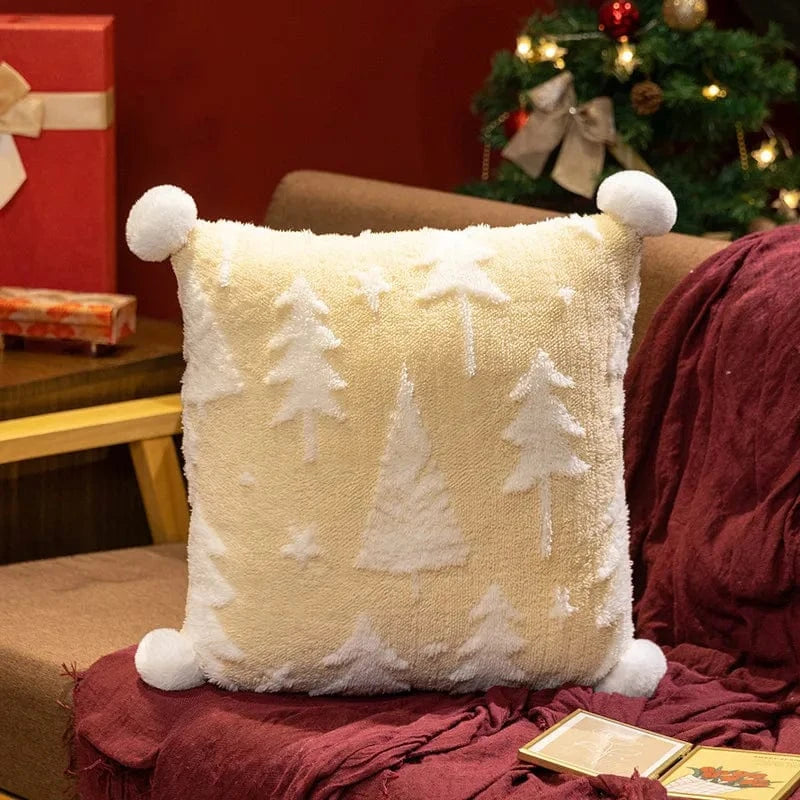 Coussin décoratif en tissu doux jaune avec motifs de sapins blancs, posé sur un canapé marron dans un salon chaleureux